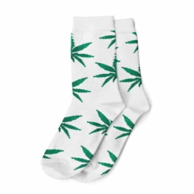 Une paire de chaussettes blanches et vertes sur le thème du cannabis, avec des motifs complexes de feuilles de cannabis, parfaites pour les amateurs de cannabis.